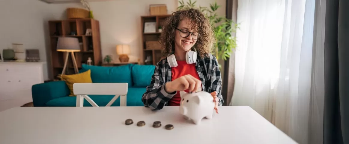 Teenager saving money in a piggy bank